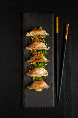 Japanese gedza dumplings. Asian food. Dark background.	