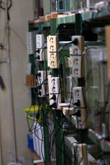 switch box. homemade shield with sockets for power lines. DIY wiring. many white rosettes, the largest white on top. creation of a high-voltage power line.