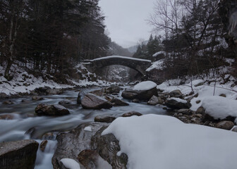 The medieval bridge of Peso in a cloudy winter day in Valle Maira