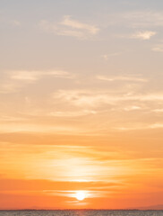 Sunset sky vertical over sea in the evening with majestic colorful orange sunlight clouds, nature landscapes background 