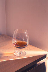 Glass and alcohol on wooden desk with dramatic light