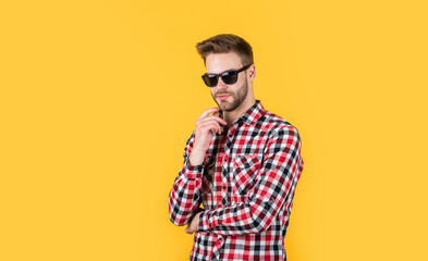 young handsome guy in checkered shirt and glasses. stylish male wear casual clothes. bearded man with bristle on unshaven face. fashion and beauty. barbershop concept. mens wear. Loving new style