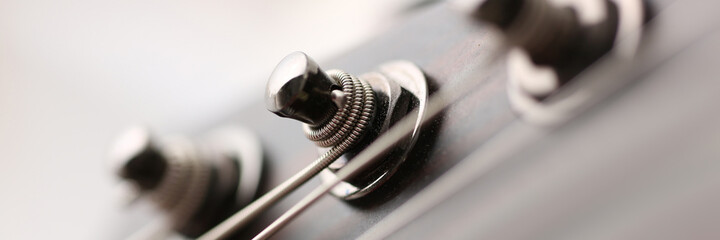 Close up of metal details on the guitar, strings are well tensed during playing the melody