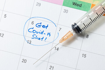 Doctor reminder covid-19 vaccine shot in calendar with syringe, medicine and vaccine concept