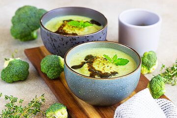 Broccoli or spinach green soup with aromatic spicy oil. Vegan healthy food. Stone background.