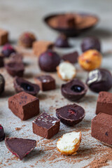 Chocolate truffles and candies on light stone background. Homemade dark chocolate truffles and candies with cocoa powder.