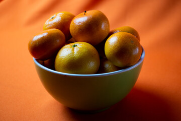 clementines in a bowl with orange background