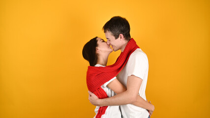 Kissing young couple, on a yellow background