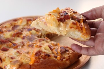 close-up pizza slice in hand