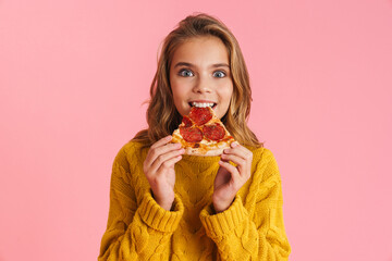 Excited beautiful blonde girl eating pizza at camera