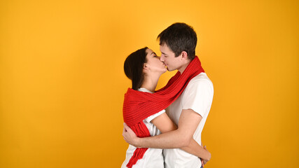 Kissing young couple, on a yellow background