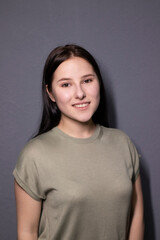 Obraz premium portrait of charming happy brunette woman in marsh color t-shirt on grey wall background. actress acting, emotion.