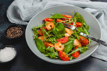 Salad of shrimp prawn and fresh vegetable, leaves of arugula, lettuce.
