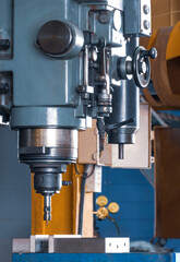 Close up of CNC milling machine with mill in chuck preparing to process metal detail in workshop area