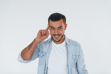 Young handsome man standing indoors against white background