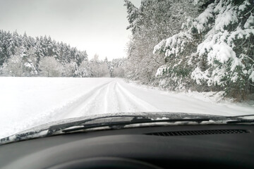 View from the car on the snow-covered forest, winter riding