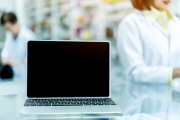 Laptop with blank screen on table in pharmacy.