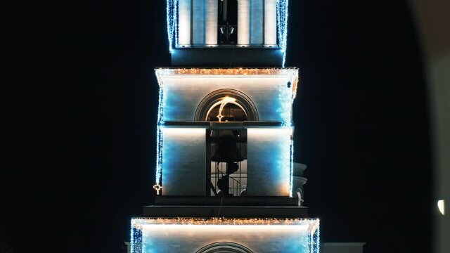 Bell Tower at Chisinau city center at night with Christmas illumination, visible behind a wall, Moldova