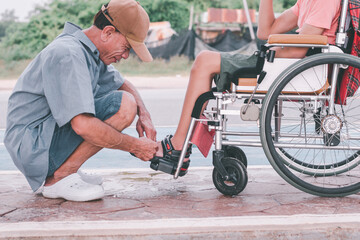 Obraz premium Asian special child on wheelchair and father in family time on public street, Parent attentive in boy daily missions, Lifestyle in the education age of disabled children, Happy disabled kid concept.