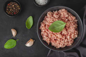 Raw minced meat in bowl on black table