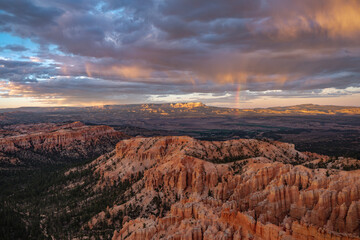 Fototapeta na wymiar Views of sandstone Hoodoos, storm clouds and a rainbow at sunset/sunrise from Inspiration Point in Bryce Canyon National Park, Utah, USA. 