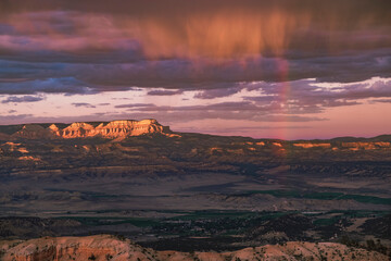 Close up views of sandstone rock formations, storm clouds and a rainbow at sunset/sunrise from Inspiration Point in Bryce Canyon National Park, Utah, USA. 