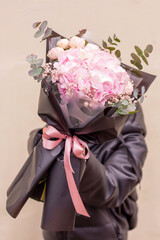Stylish fllowers bouquet with pink hydrangea and roses in contrasting black wrapping paper. Designer flower bouquet from a florist