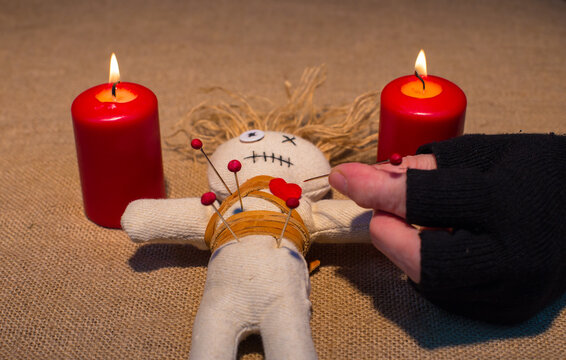 Cropped Hand Inserting Straight Pin In Voodoo Doll