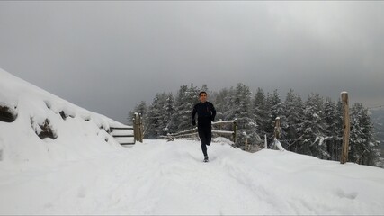 Fototapeta na wymiar young man running in a snowed mountain