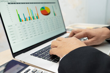 Asian accountant type keyboard to enter information, working, calculate and analyzing report chart graph project accounting with notebook in modern office, finance and business concept.