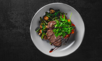 Roastbeef salad with green beans and mushroom in a bowl on Dark grey black slate background