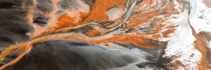 Aerial view of river delta colored by runoff, near Hvammur, Iceland