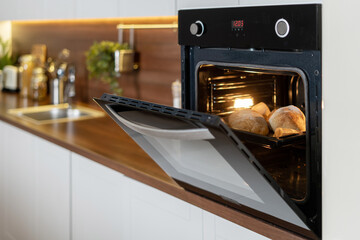 Modern and open oven with baked loaf inside