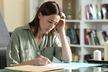 Sad woman ready to sign a contract at home