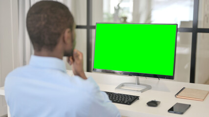 Businessman Looking at Desktop with Green Chroma Key Screen