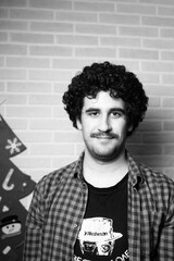 Black and white monochrome portrait of a red curly haired man with a mustache who looks like the...