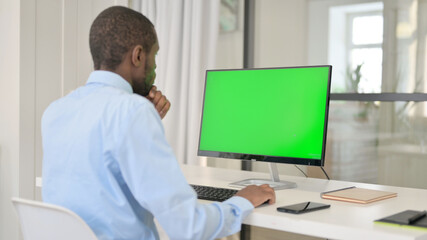 Fototapeta na wymiar Businessman Celebrating While Using Desktop with Green Chroma Key Screen