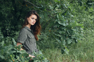 Woman in the forest Keeps his hands in his pockets with green leaves background