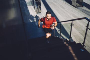 Obraz premium Determined male athlete running upstairs during workout