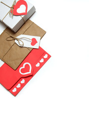 Gifts, tied with twine with bows and labels with red paper hearts, love letter in red envelope with hearts on white background isolated. Love, Valentine's, women's day, relations, romantic concept