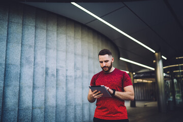 Focused male using tablet during workout break