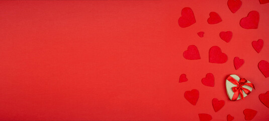 Red hearts with a gift on a red background.Valentine's Day, background with space for text.