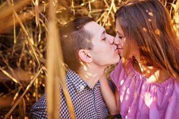 Beautiful couple embracing in fields of reeds at sunset. Lovers being affectionate in beautiful autumn panorama.
