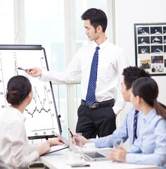 Fototapeta premium Businessman pointing at graph during presentation in boardroom
