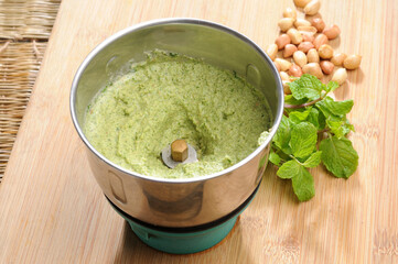green mint chutney or dip with mint leaves aside