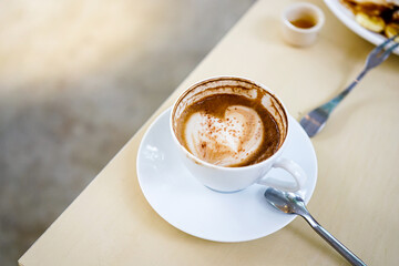 selective focus, a cup of hot latte coffee with beautiful milk foam latte art texture on wood table. Overhead view, copy space. Advertising for cafe menu. Coffee shop menu
