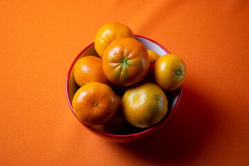 
fresh clementines on orange background