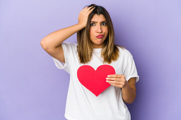 Young indian woman holding a valentines day heart isolated being shocked, she has remembered important meeting.