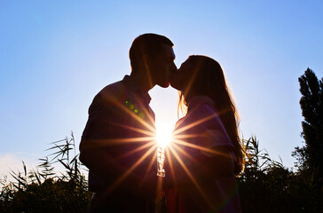 Silhouette of a young couple kissing at the beach