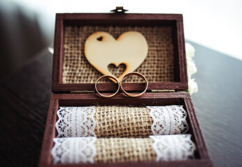 Wedding rings in the wooden box with a heart. Wedding details. Gift for Valentine day